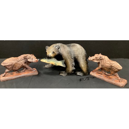 58 - A pair of carved figures, warthogs, 14.5cm x 24.5cm,  a larger Black Forest style Bear and Fish (3)