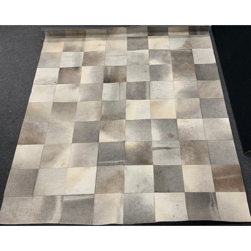 119 - A contemporary cow hide rug or carpet, geometric patchwork design, 292cm x 237cm