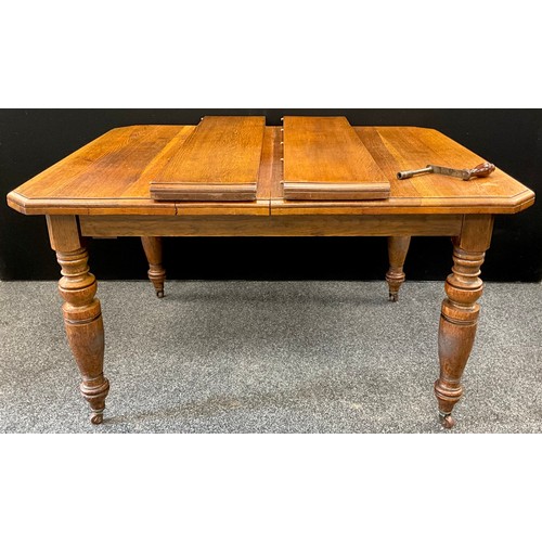 133 - A Victorian oak extending dining table, the top with canted corners, two additional leaves, turned l... 