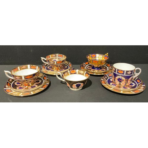 52 - A Royal Crown Derby 1128 Imari pattern trio, c.1934; an associated pair of 1128 Imari trios; another... 