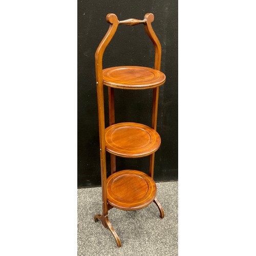 202 - An Edwardian mahogany three tier folding cake stand, outlined with boxwood stringing, c.,1905