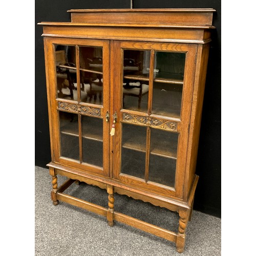 111A - An Arts and Crafts style oak cabinet, 149.5cm high x 106.5cm wide x 34.5cm deep, early 20th century.