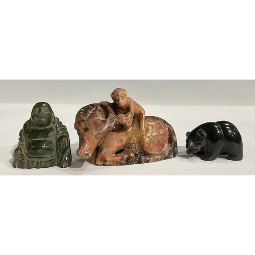 81 - A Chinese hardstone buddha; a soapstone bear with fish; a soapstone monkey on oxen