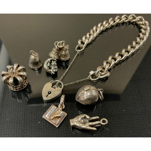 277 - A 925 silver bracelet, padlock clasp,  seven loose charms, crown, Acorn, bells, hand etc 46g gross; ... 