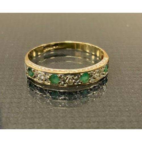 283 - A diamond and emerald half eternity ring, alternate set with four emeralds and three three round bri... 