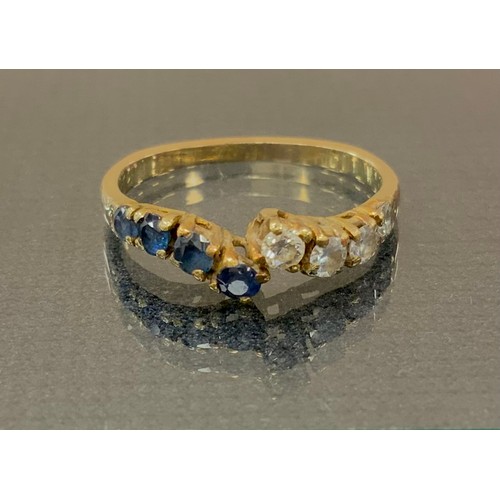 288 - A diamond and sapphire dress ring, off set crest with slightly graduated four stone set shoulders, u... 