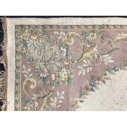 162A - A large Chinese woven wool rug,in tones of pink, cream and green, 284cm x 225cm; another 350cm x 251... 