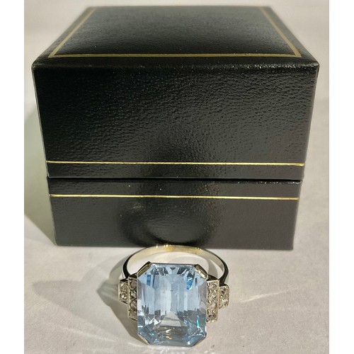 157 - An unmarked ring, possibly platinum, set with a faceted aquamarine stone, each shoulder set with dia... 