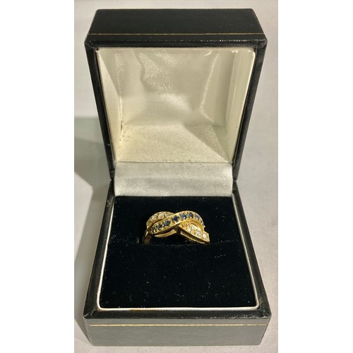 161 - An 18ct gold diamond and sapphire crossover ring, size K/L, 4.9g, boxed