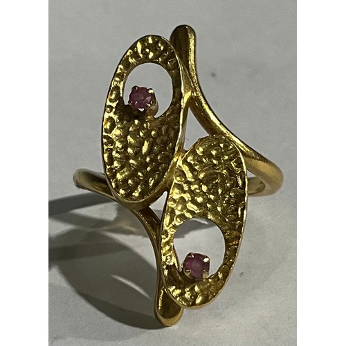 162 - An 18ct gold modernist design crossover ring, as pair of stylised textured flowerheads, each set wit... 