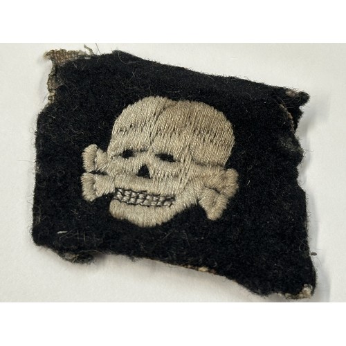 2192 - WW2 Third Reich SS Totenkopfverbande rare early pattern collar tab with left facing skull. This item... 