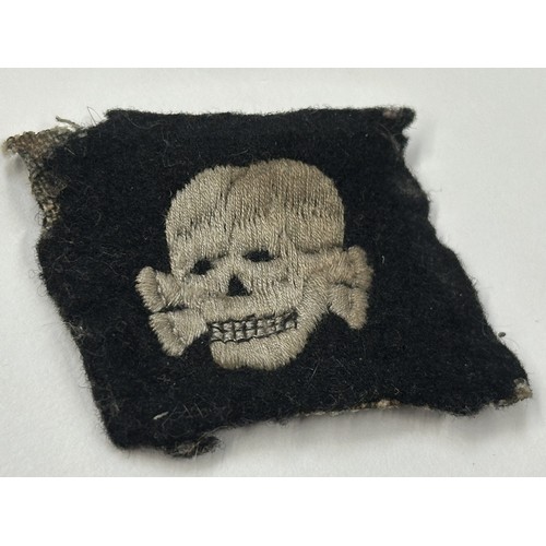 2192 - WW2 Third Reich SS Totenkopfverbande rare early pattern collar tab with left facing skull. This item... 