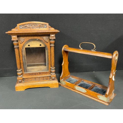 403 - An oak bracket clock case, arched pediment with carved frieze, pair of turned column supports, bevel... 