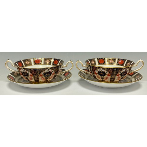 22 - A pair Royal Crown Derby Imari palette 1128 pattern two handled soup dishes on stands, second qualit... 