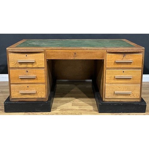 533 - A mid-20th century oak desk, rectangular top with inset writing surface, above a pair of slides and ... 