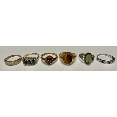 552 - A 9ct gold tiger eye signet ring, size T, 3.6g; four 9ct gold rings set with sapphire and clear ston... 