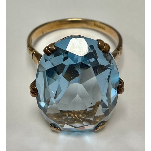 555 - A South African unmarked gold ring, set with a single faceted blue stone, size R, 6.8g