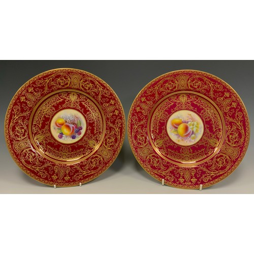 347 - A pair of Royal Worcester hand painted cabinet plates, the central panels with Peaches and Berries a... 