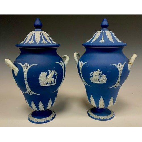 A matched pair of Wedgwood jasperware twin handled urns and covers ...