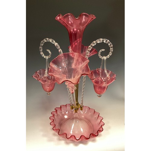 396 - A Victorian cranberry glass epergne, three wavy edged trumpets and a pair of baskets suspended on tw... 