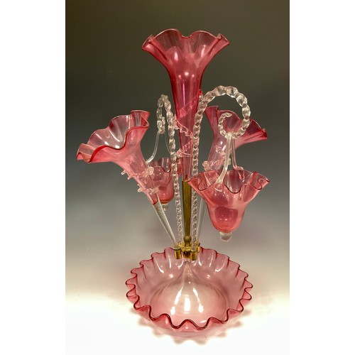 396 - A Victorian cranberry glass epergne, three wavy edged trumpets and a pair of baskets suspended on tw... 