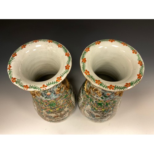 423 - A pair of 19th century Chinese Canton famille Rose vases, decorated with traditional figure panels, ... 