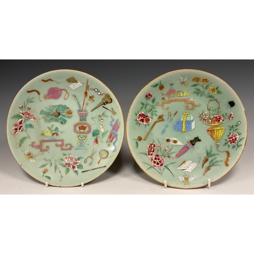 424 - A pair of Chinese Famille Rose celadon plates, decorated with traditional motifs of instruments, wea... 