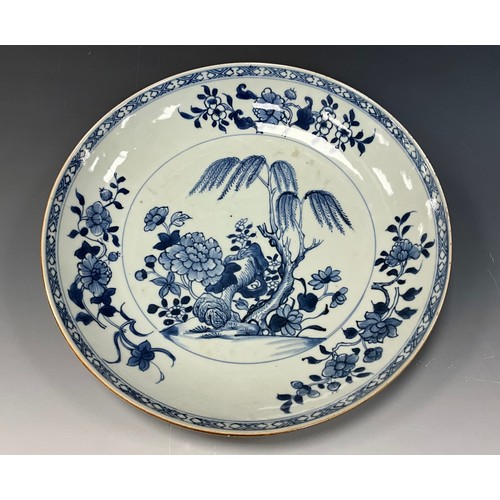 432 - An 18th century Chinese blue and white serving dish of shaped oval form, the deep bowl decorated wit... 