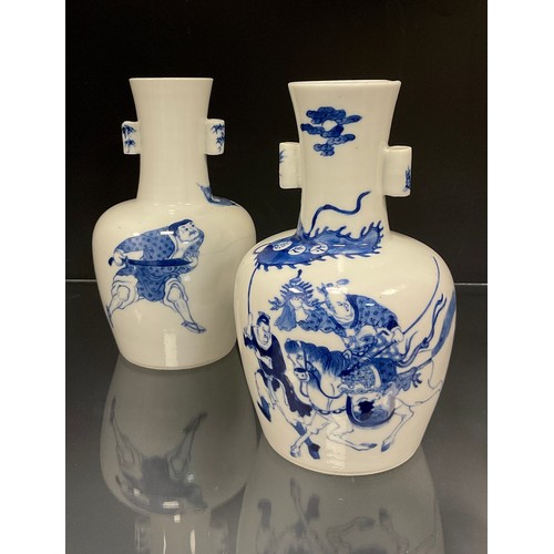 426 - A pair of Chinese Kangxi type blue and white arrow vases, decorated in under glazed blue with depict... 