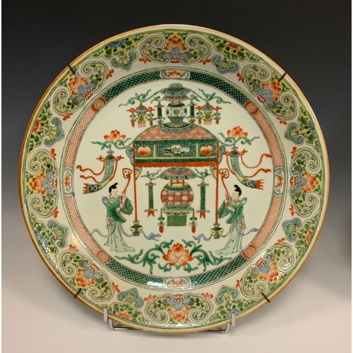 425 - A pair of Chinese famille vert dished circular chargers, each decorated with a Temple and Alter, fla... 