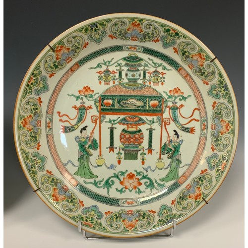 425 - A pair of Chinese famille vert dished circular chargers, each decorated with a Temple and Alter, fla... 