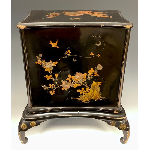 438 - A Japanese black lacquered serpentine two door cabinet, decorated with insects and birds amongst bra... 