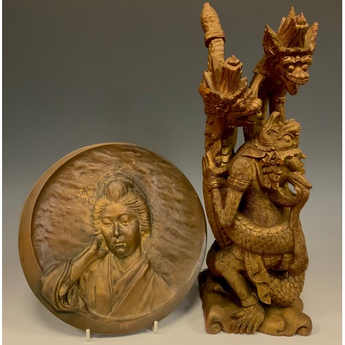 439 - A Japanese Bronze circular plaque, with a Portrait of a Geisha, cast in high relief, within a ‘Cresc... 