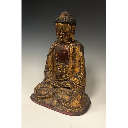 437 - A Chinese or Tibetan gilt and red patinated cast metal figure, Buddha seated crossed legs at prayer,... 