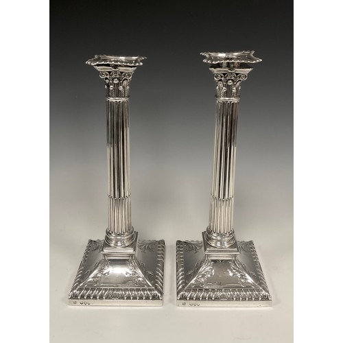 62 - A pair of Victorian silver Corinthian column candlesticks, Lambert & Co, London 1893, removable scon... 