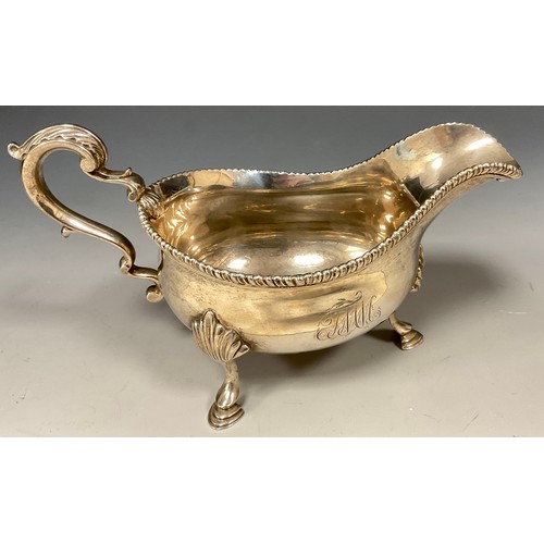 16 - A George III silver sauce boat, monogrammed FMM, gadrooned rim, acanthus leaf capped scrolling handl... 