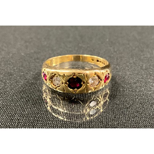 190 - A diamond and ruby ring, set with three graduated red rubies, divided by round brilliant cut diamond... 