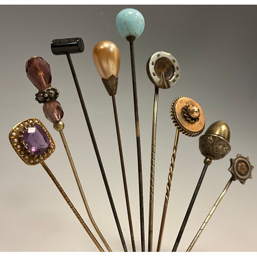 176 - A collection of nine 19th century and later scarf pins, including 9ct gold mounted pale pinky purple... 