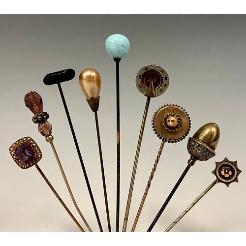 176 - A collection of nine 19th century and later scarf pins, including 9ct gold mounted pale pinky purple... 