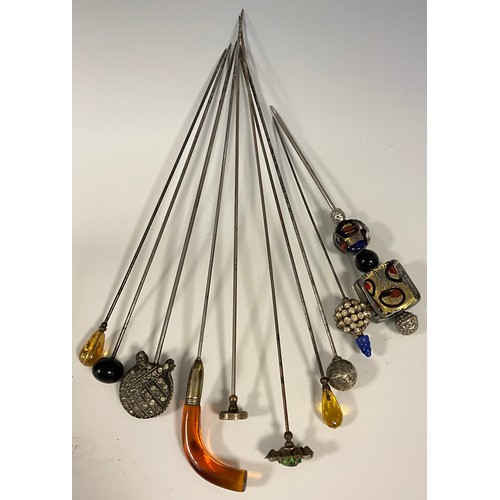 178 - A collection of ten Victorian and later hat and scarf pins, including Walking cane topped curved amb... 