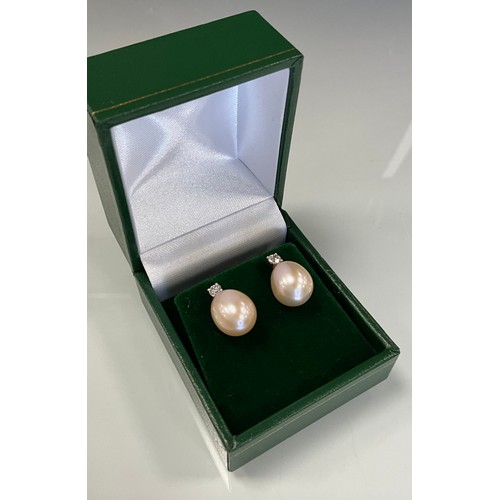 226 - A pair of diamond and peach coloured cultured pearl rose gold earrings, total diamond weight 0.26ct,... 