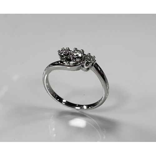 205 - A diamond twist ring, linear set with three round brilliant cut diamonds, total estimated diamond we... 