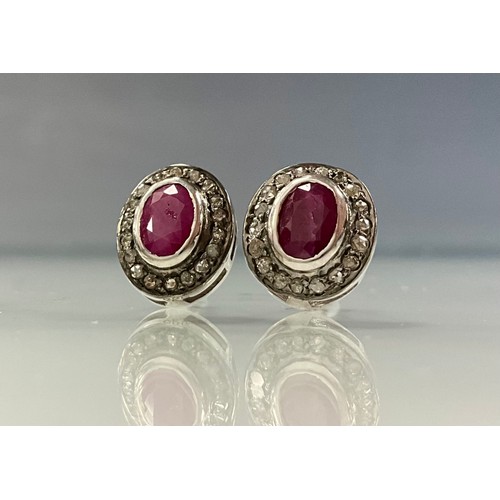 227 - A pair of diamond and ruby earrings, central collar set oval ruby surrounded by a halo of rose cut d... 