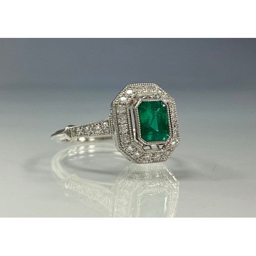 287 - An emerald and diamond cluster ring, central step cut Columbian emerald 0.71ct, surrounded by halo o... 