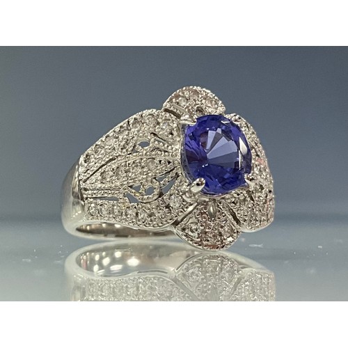 275 - An Art Deco style tanzanite and diamond ring, central oval tanzanite approx 1.52ct, claw set above d... 