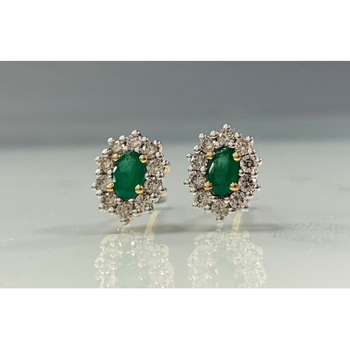 230 - A pair of emerald and diamond oval cluster earrings, central oval emeralds surrounded by ten yellow ... 