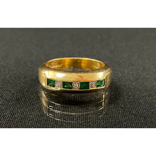 207 - A emerald and diamond ring, linear set with alternating baguette cut emeralds and princess cut diamo... 