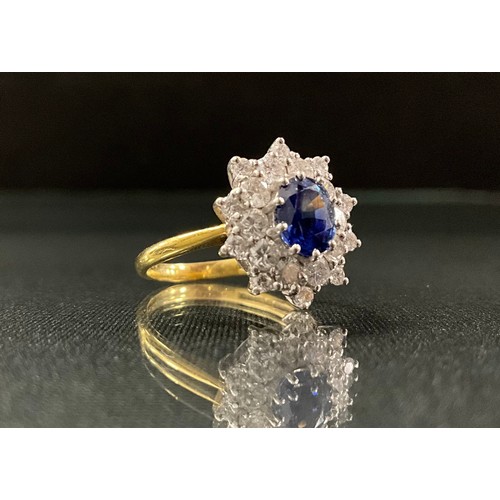 251 - A sapphire and diamond ring, central oval strong blue sapphire, approx 0.75ct, surrounded by a ten p... 