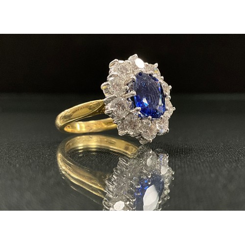 217 - A large impressive sapphire and diamond cluster ring, central oval vibrant blue sapphire, approx 1.9... 