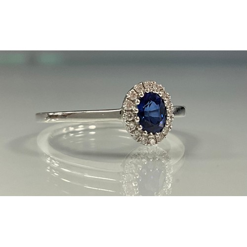 252 - A sapphire and diamond ring, central oval vibrant blue sapphire approx 0.39ct, surrounded by a halo ... 